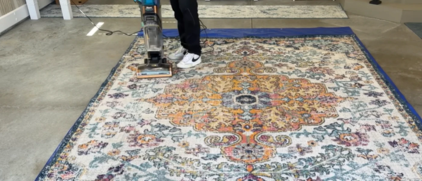 Technician using professional equipment to clean a patterned area rug