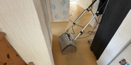 Carpet cleaning machine working in a residential hallway